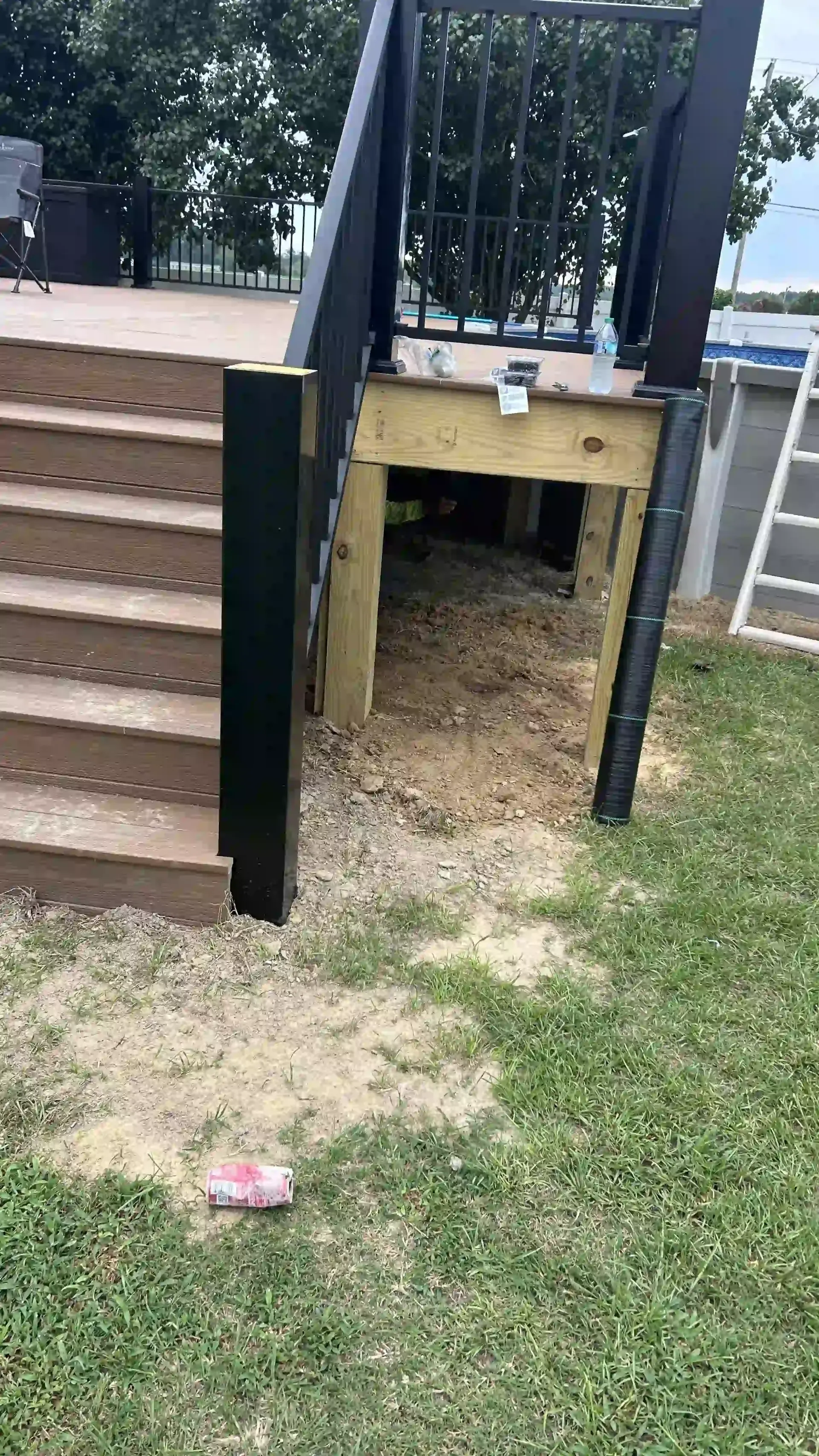 Backyard play structure with stairs and a small crawl-through opening under the deck