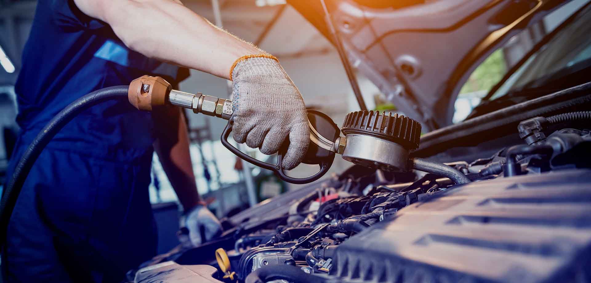 A mechanic is working on the engine of a car in a garage.