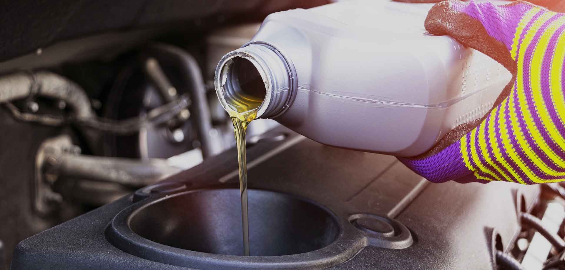 A person is pouring oil into a car engine.