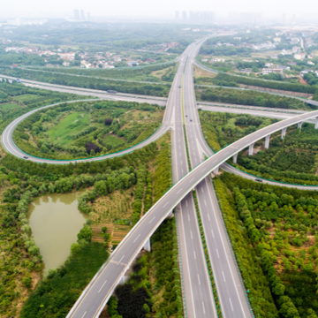 An aerial view of a highway intersection surrounded by trees.