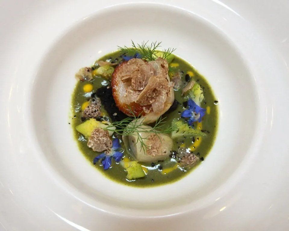 zuppetta di pesce guarnita con fiorellini e finocchietto