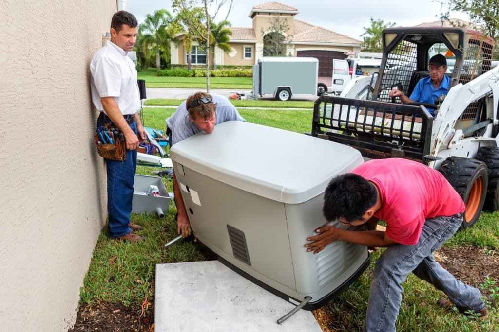 A group of men are working on a generator outside of a house