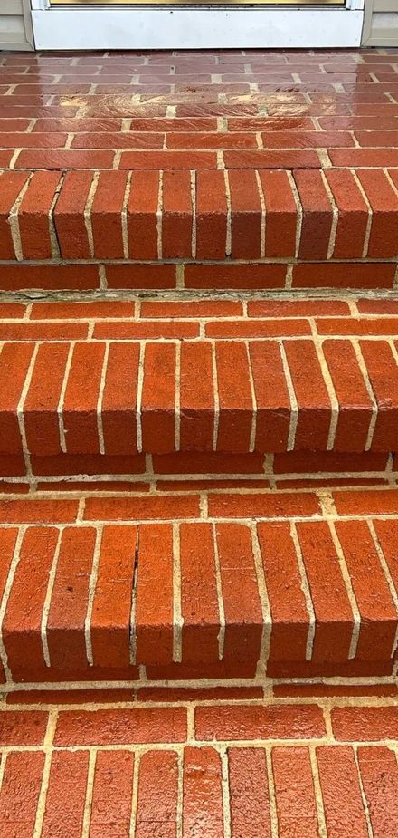Red brick steps with white mortar leading up to a doorway