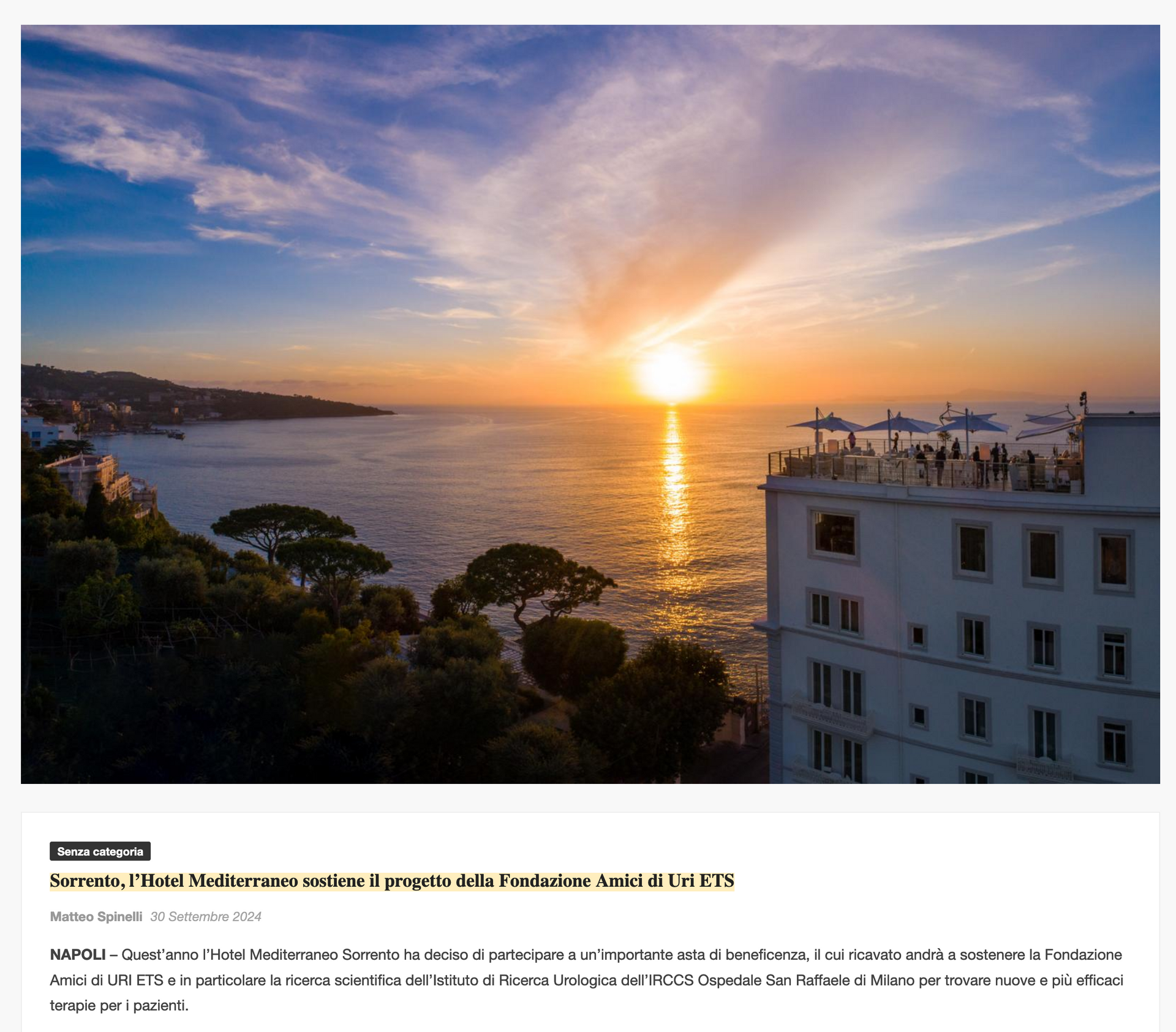A sunset over the Mediterranean Sea, viewed from the terrace of a multi-story white building in Naples.