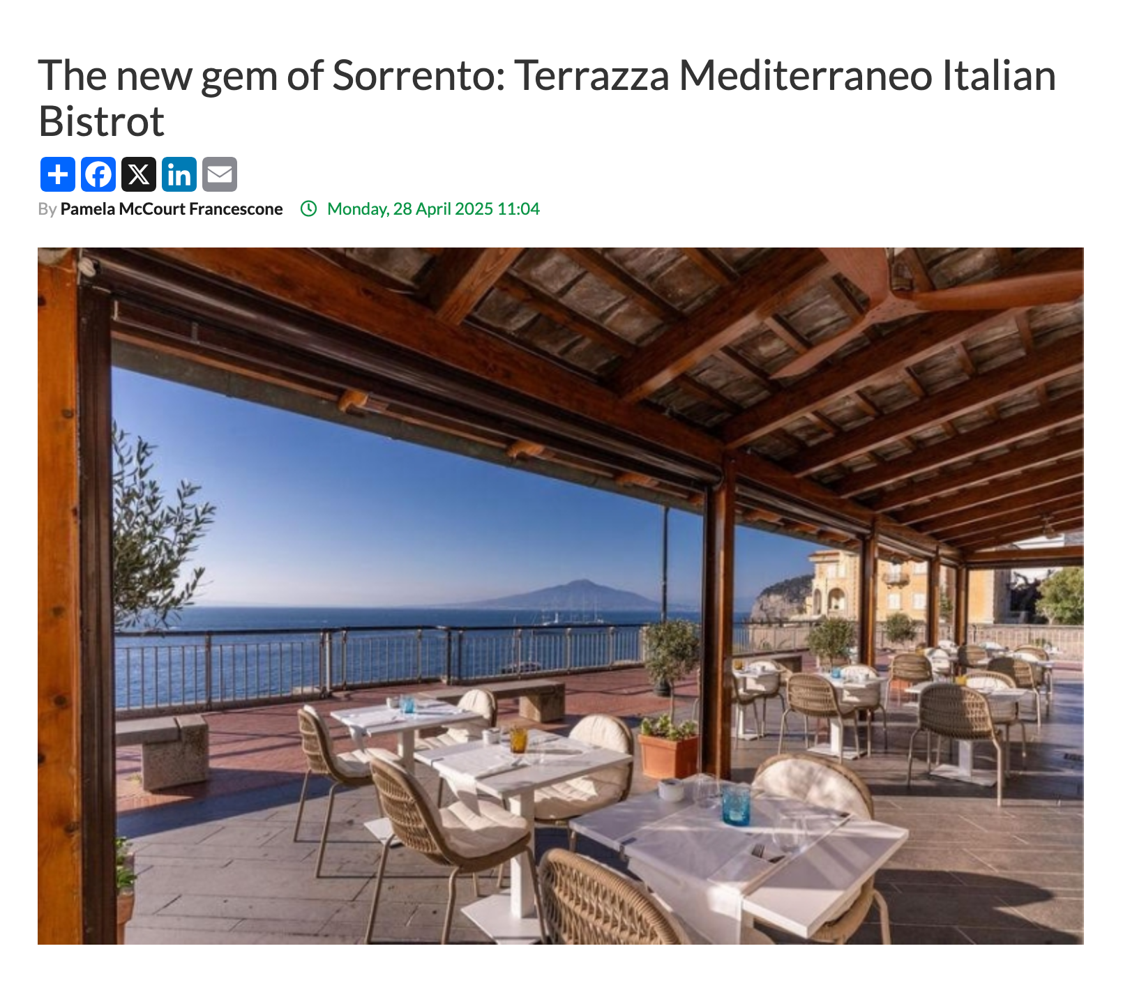 An outdoor restaurant terrace in Sorrento overlooking the sea, featuring dining tables with views of a distant mountain.