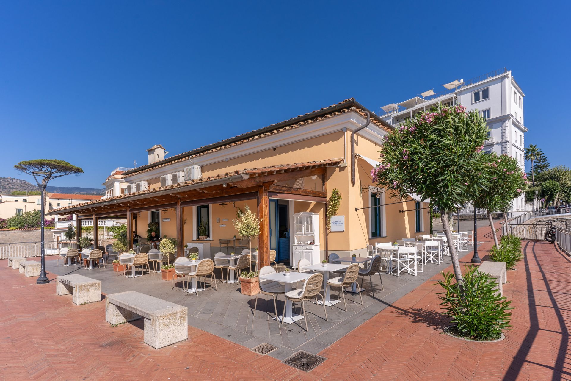 Terrazza Mediterraneo con tavoli e sedie in una strada soleggiata