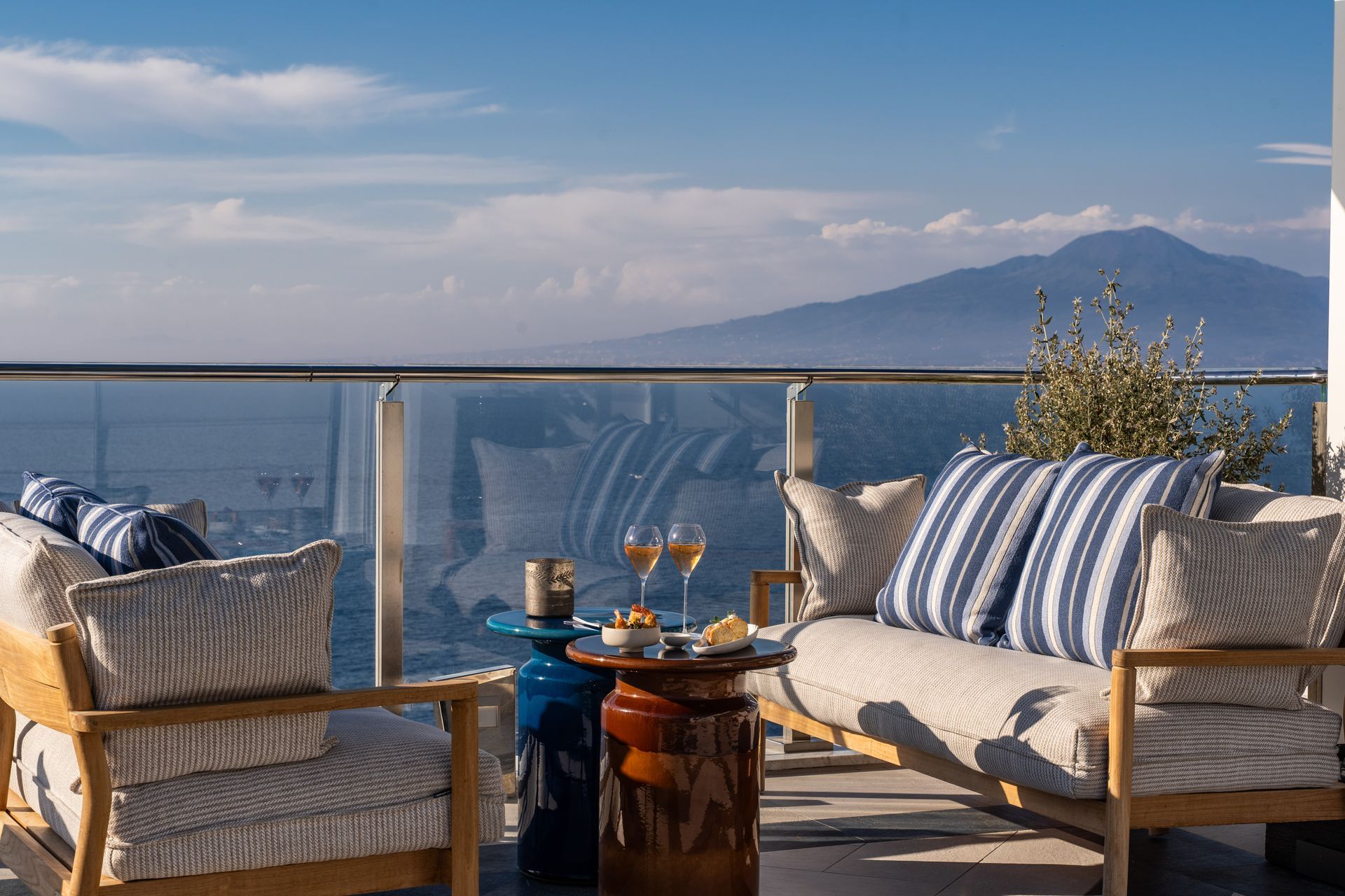 Balcony lounge with striped chairs, drinks on a small table