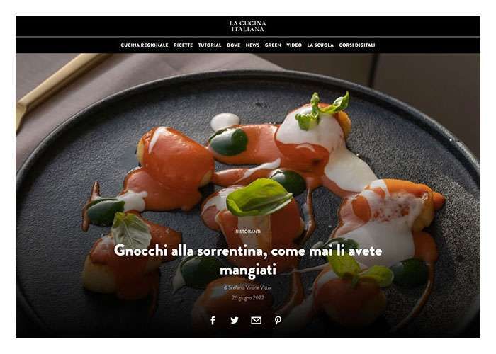 A gourmet dish of gnocchi with tomato sauce and mozzarella on a black plate, featured on a food blog website.