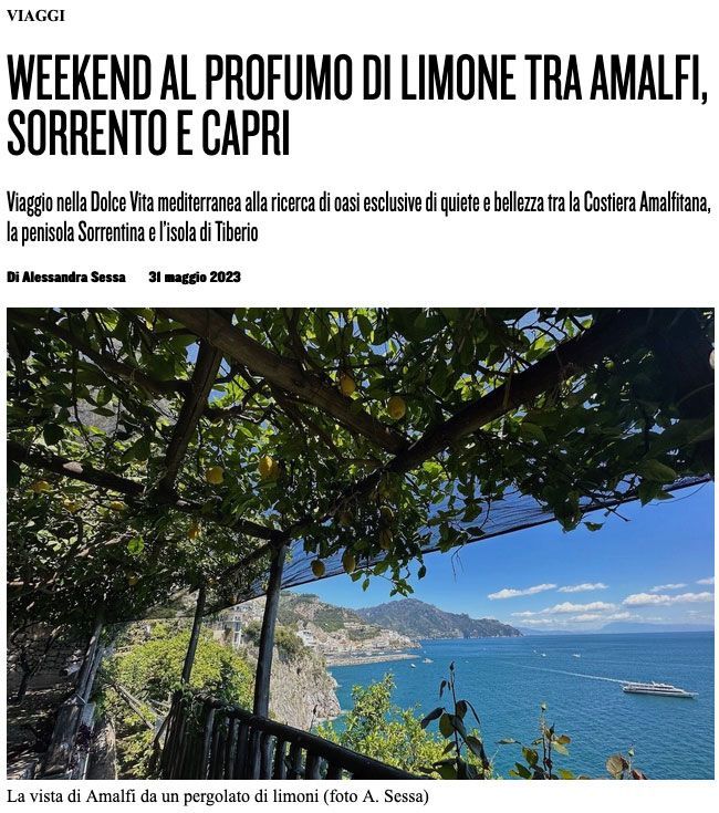 A lemon grove trellis overlooks the Amalfi Coast, with cliffs and the blue Mediterranean Sea visible in the distance.