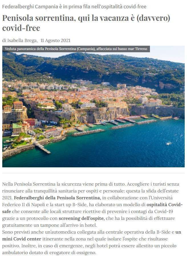 An aerial view of the Sorrento Peninsula coastline with colorful buildings on cliffs overlooking the blue sea.