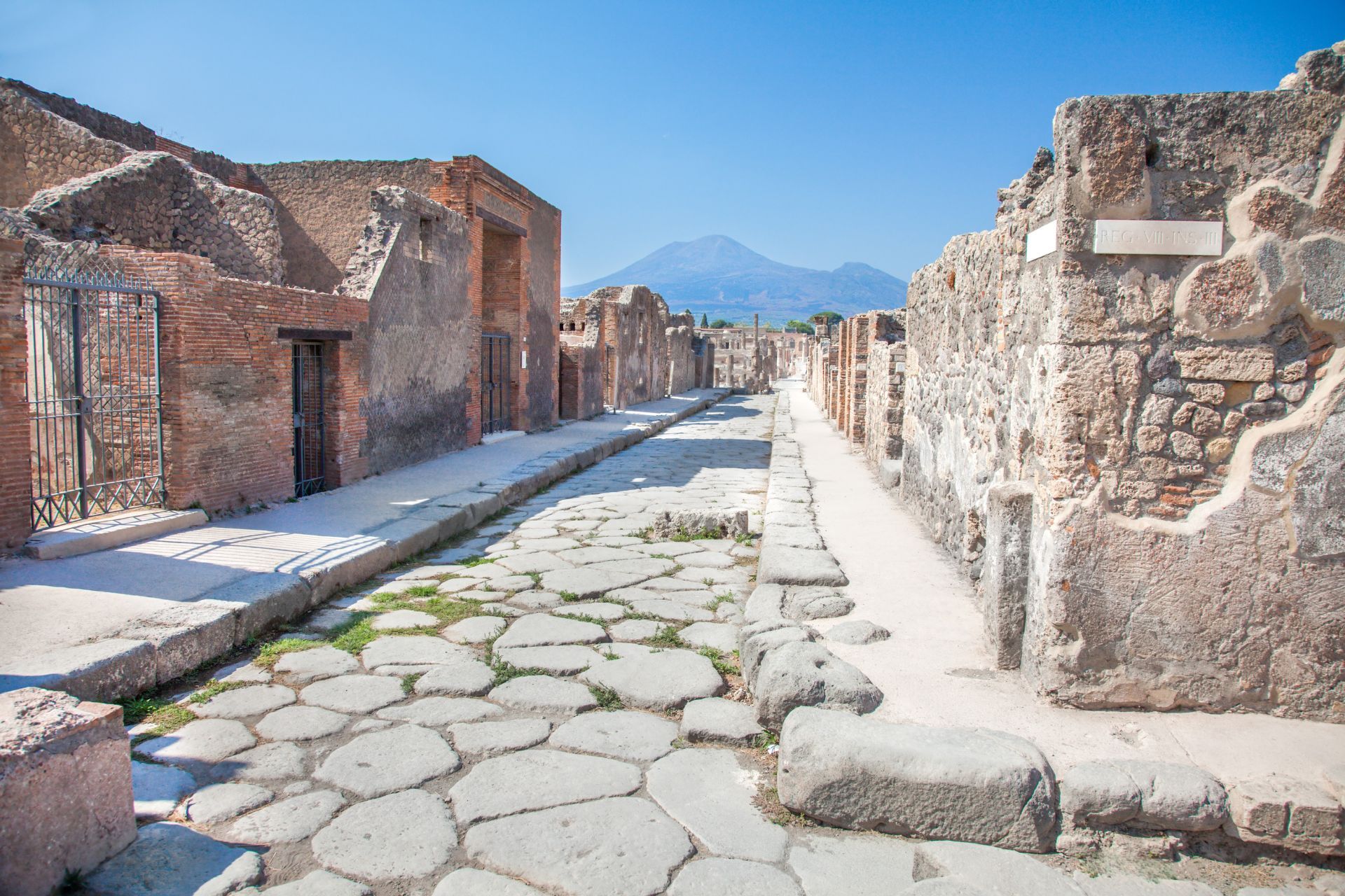A stop on the Pompeii tour: an ancient paved street with Mount Vesuvius in the background