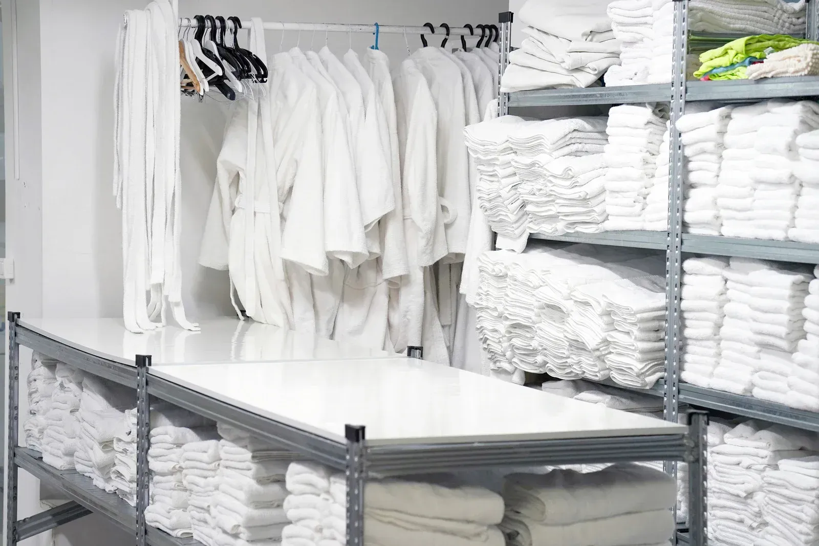 A room filled with lots of white towels and robes.