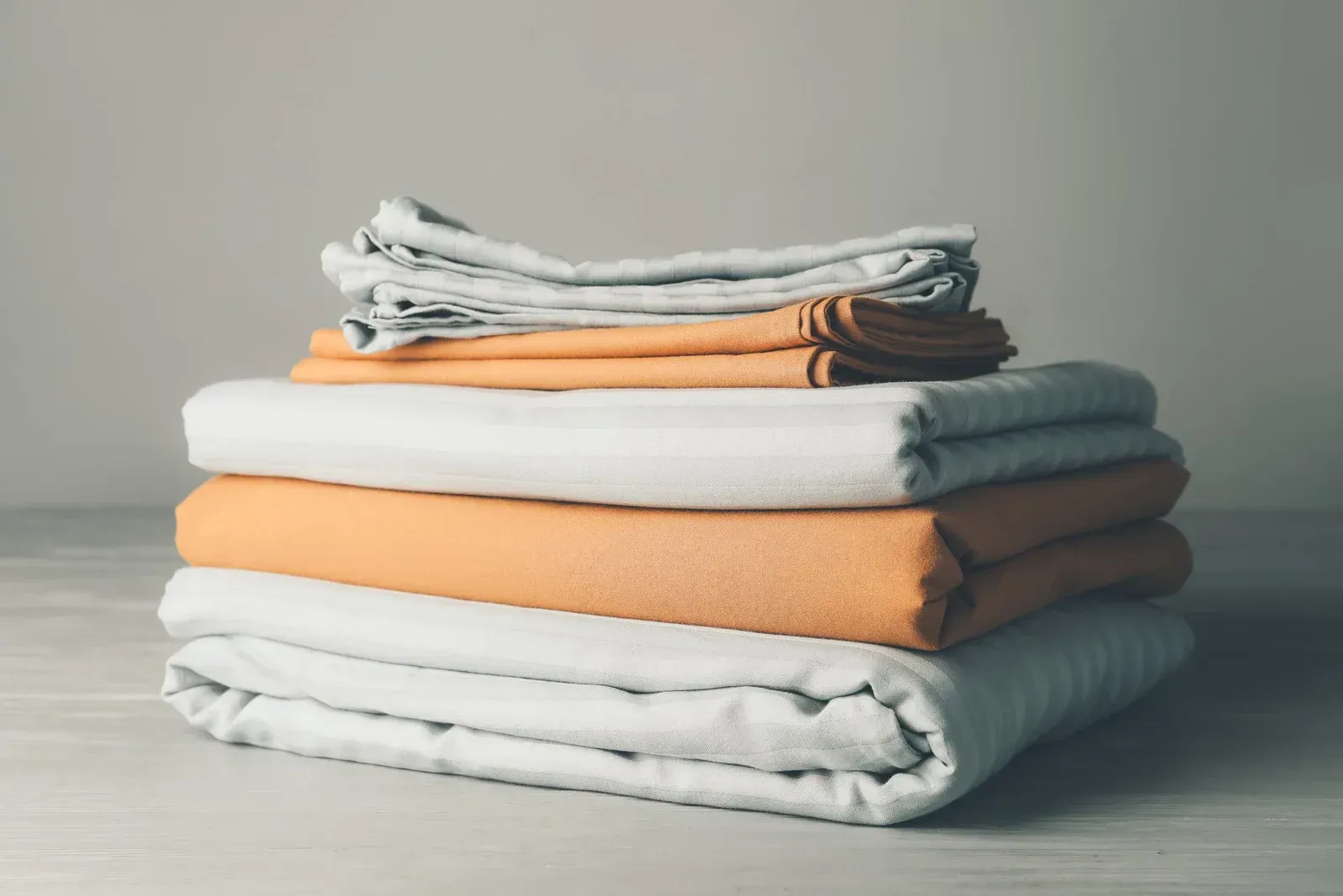 A pile of blankets stacked on top of each other on a table.