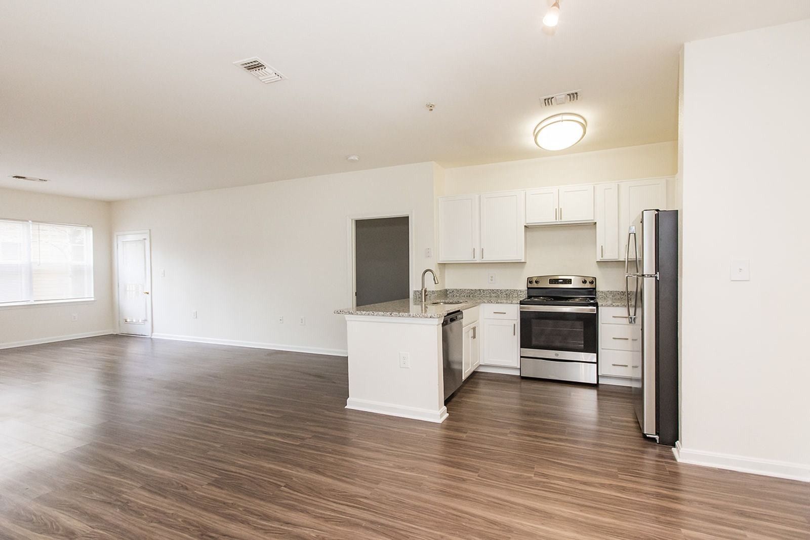 Kitchen and living area with hardwood flooring at Park Station Apartments.