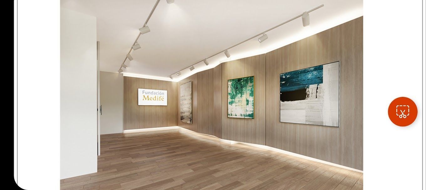 Sala de galería moderna vacía con suelos de madera, paredes blancas y obras de arte enmarcadas bajo iluminación de riel.