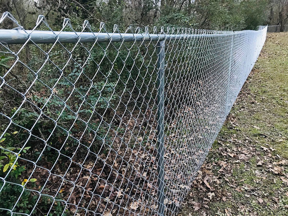 A black metal fence with a shadow on a white background.