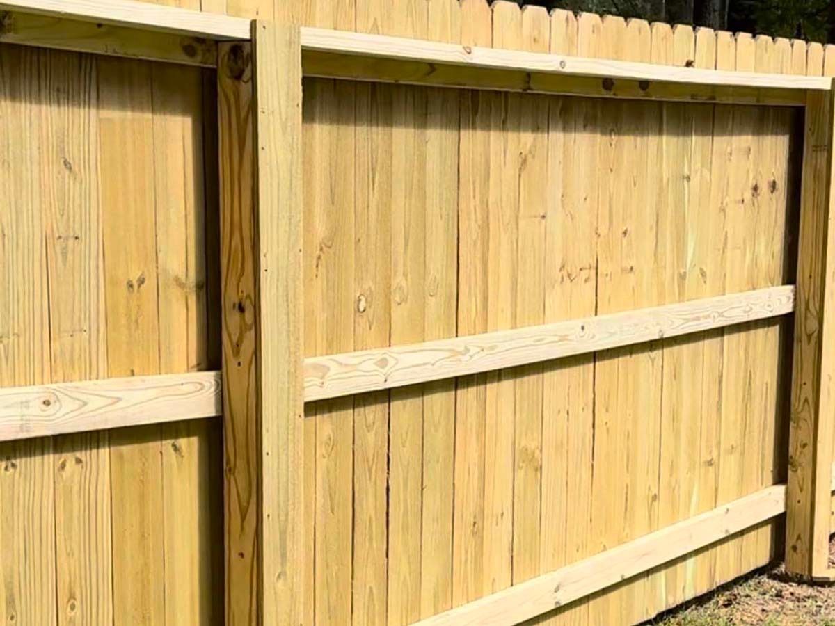Wooden fence with vertical planks and horizontal support beams.