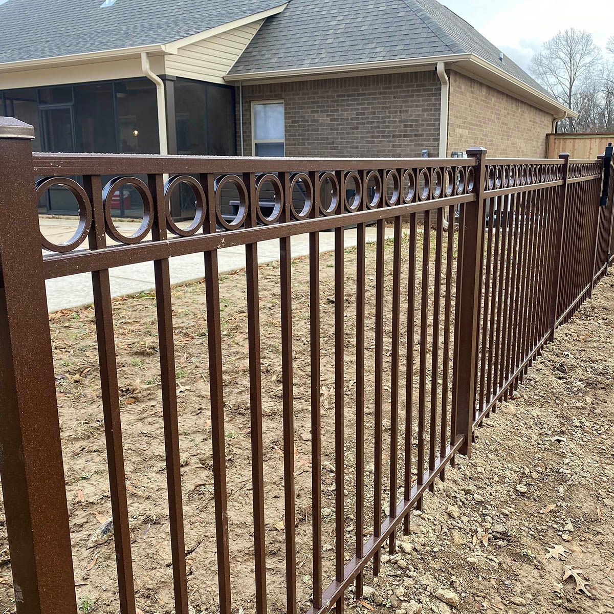 A black metal fence with a shadow on a white background.