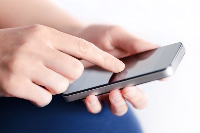 A person is using a smart phone with their finger on the screen.