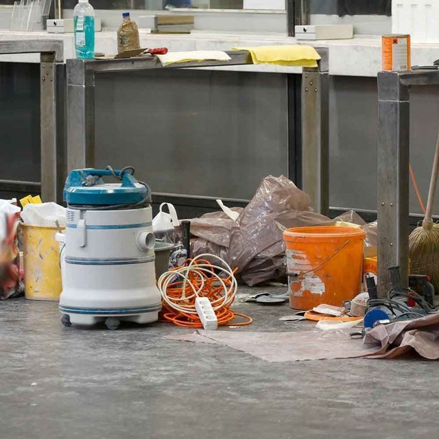A vacuum cleaner is sitting on the floor in a messy room