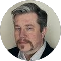 A man with a beard and gray hair is in a circle.