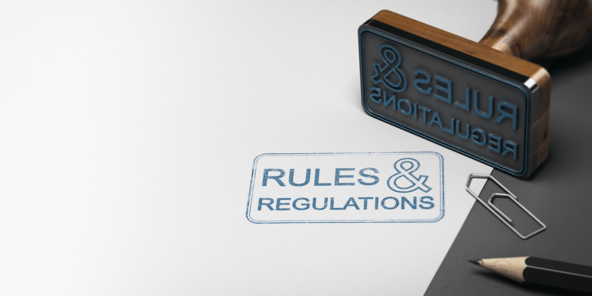 A stamp that says `` rules & regulations '' is on a piece of paper next to a pencil.