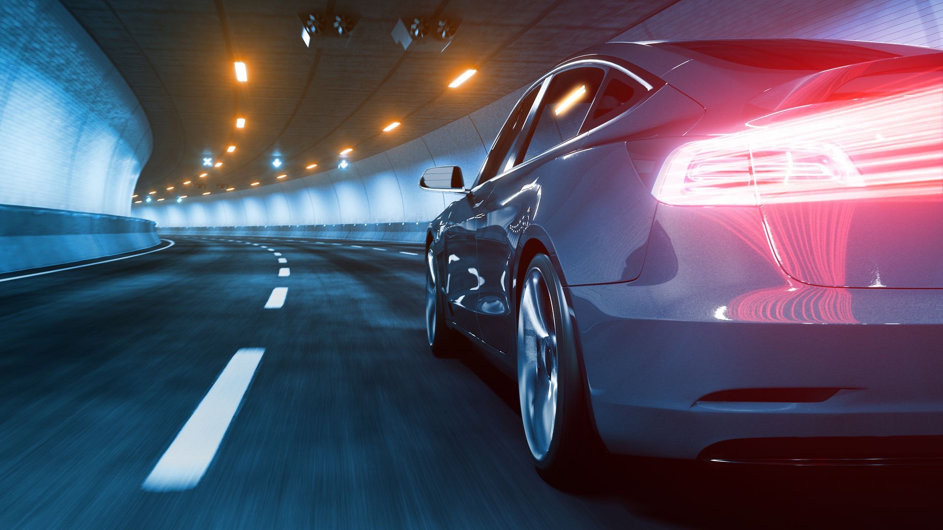 A car is driving through a tunnel at night.