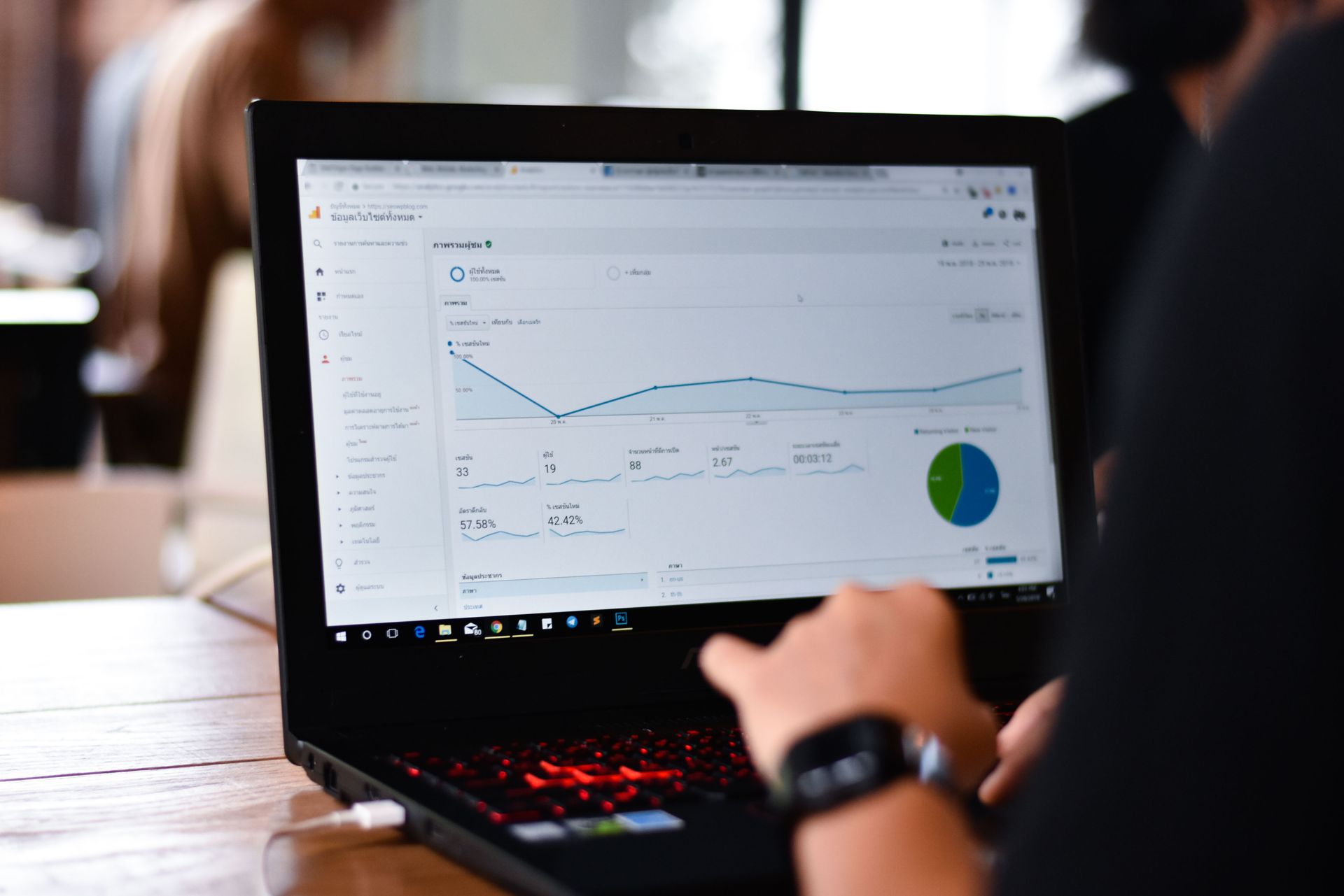A person is using a laptop computer with a graph on the screen.