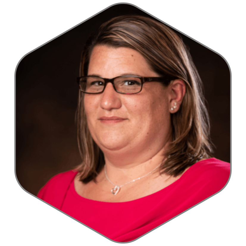 A woman wearing glasses and a red shirt is in a hexagon.