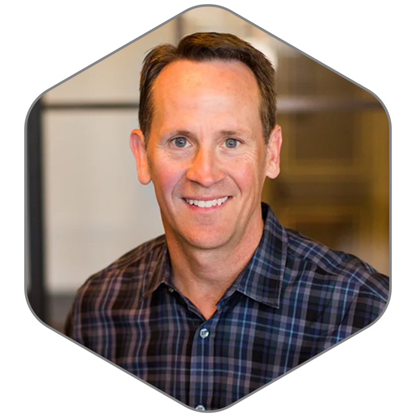 A man in a plaid shirt is smiling for the camera.