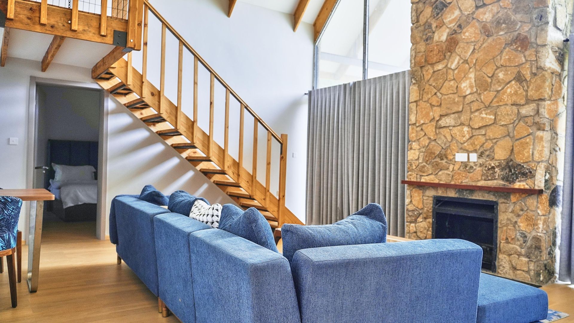 A living room with a blue couch and stairs