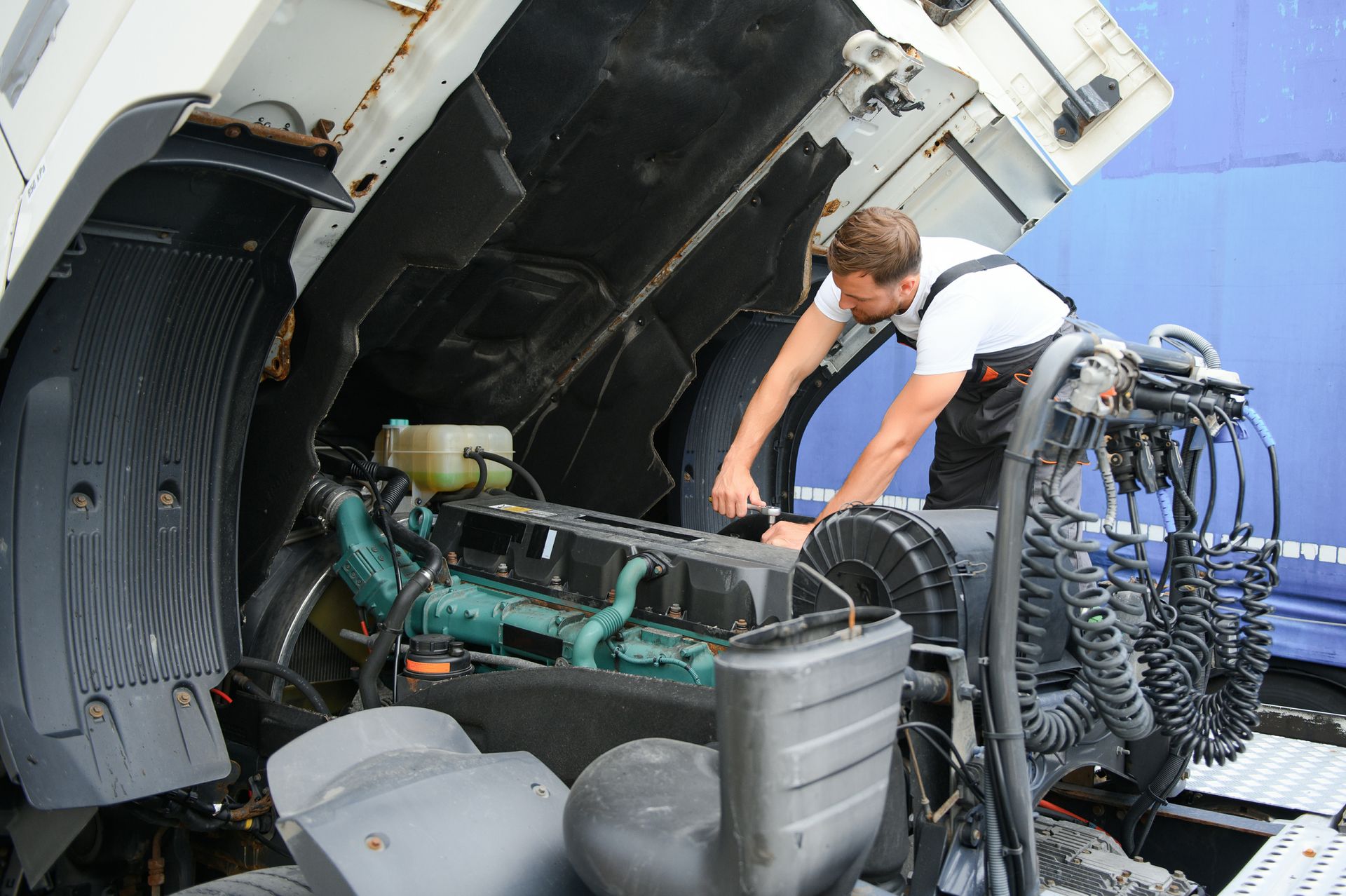 Certified mechanic repairing a commercial truck.