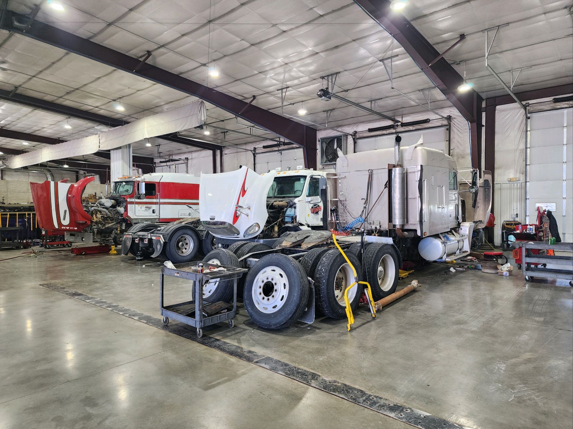 A large truck is parked in a large garage.