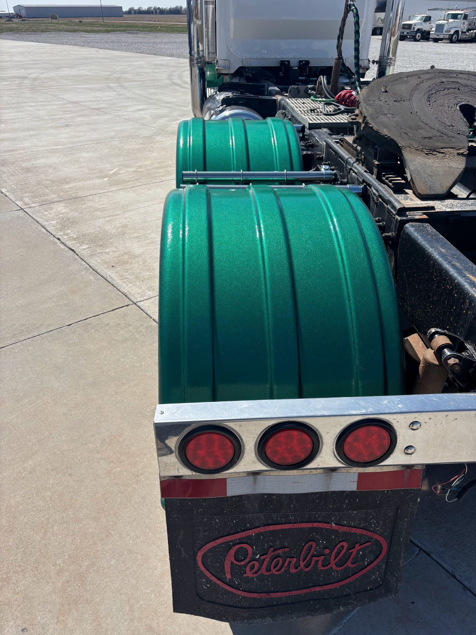 A green peterbilt semi truck is parked on the side of the road