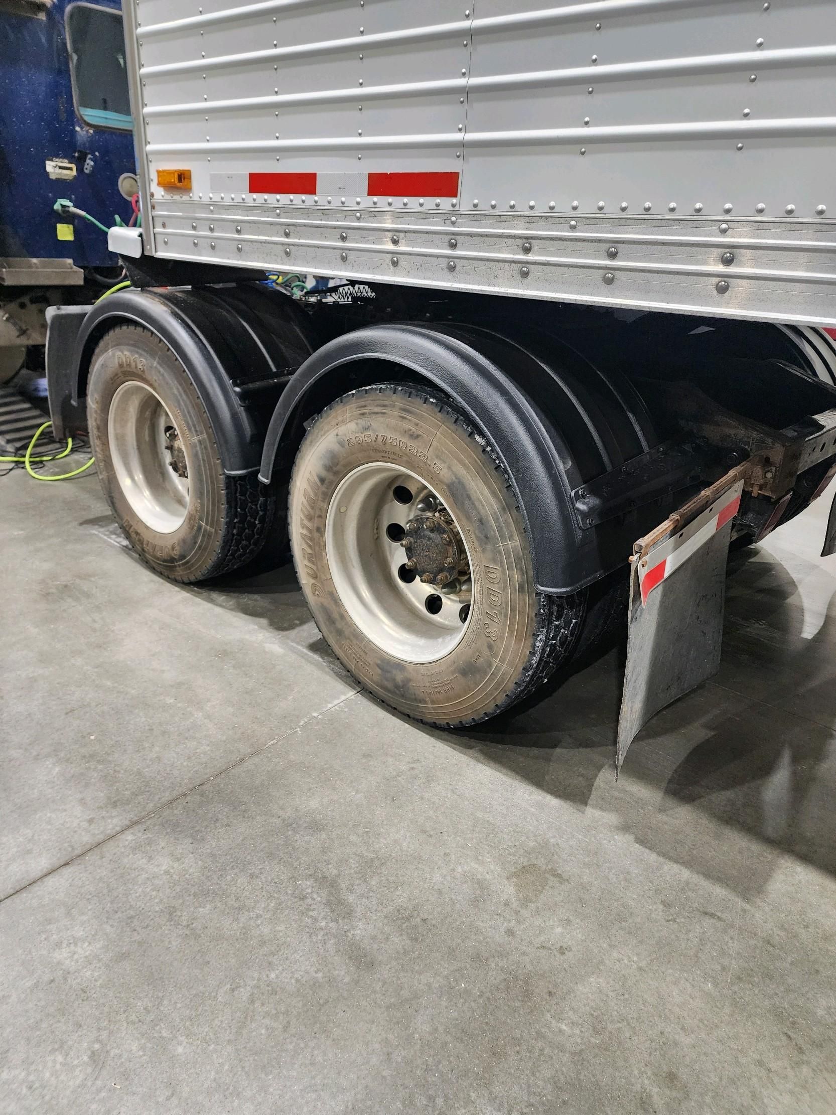 A semi truck with a trailer attached to it is parked in a garage.