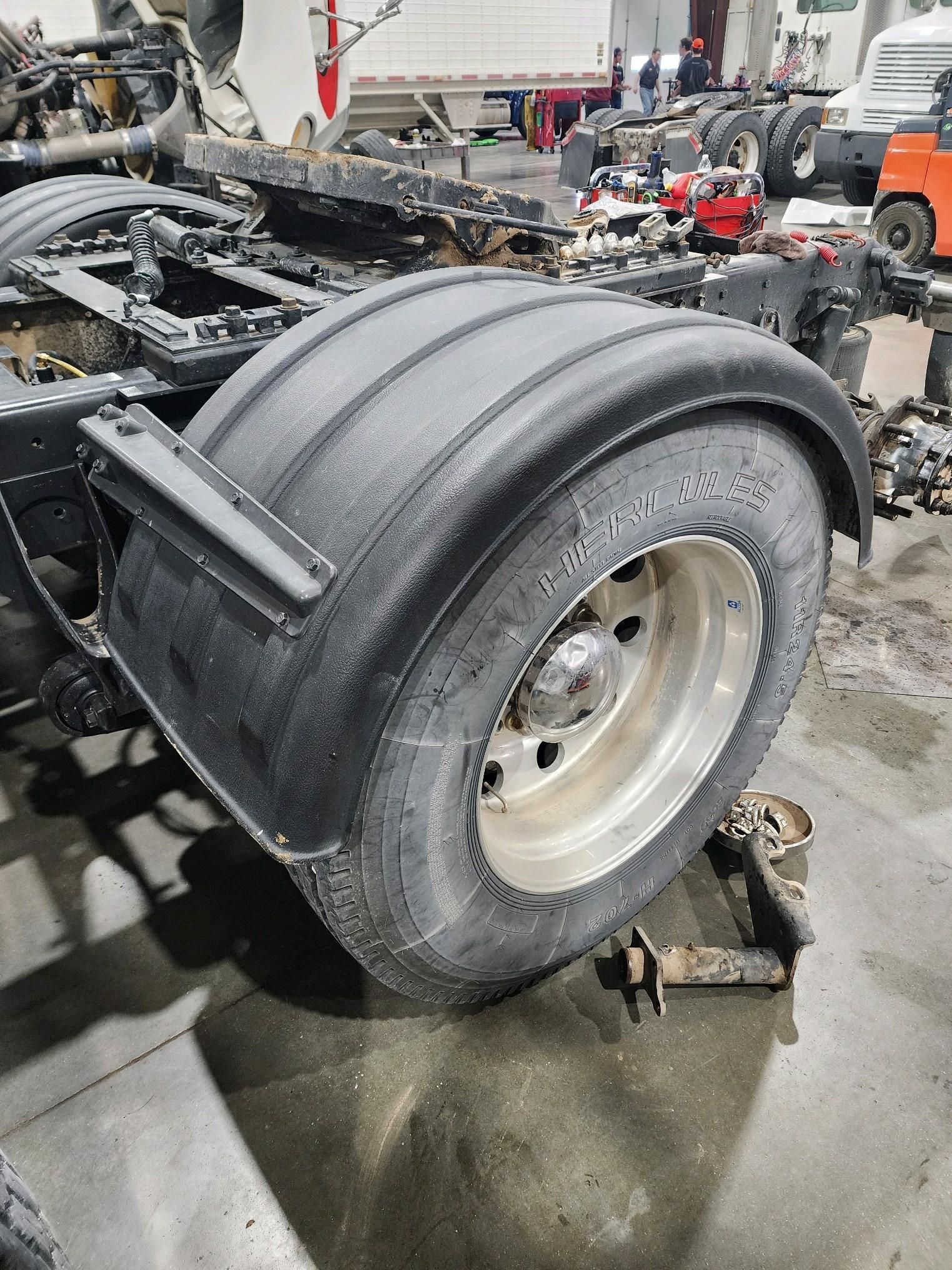 A close up of a tire on a truck in a garage.