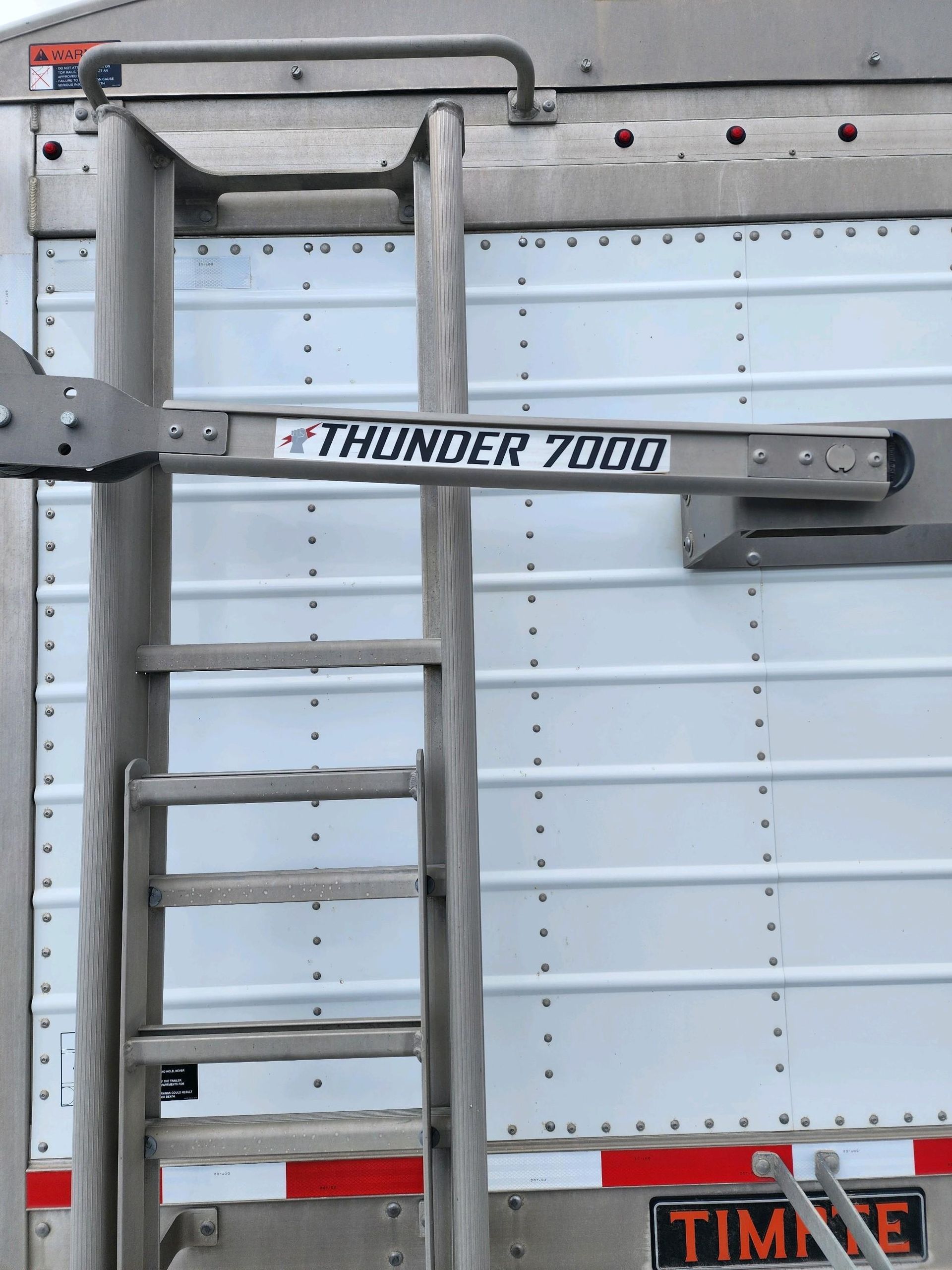 A ladder attached to a trailer that says thunder 7000
