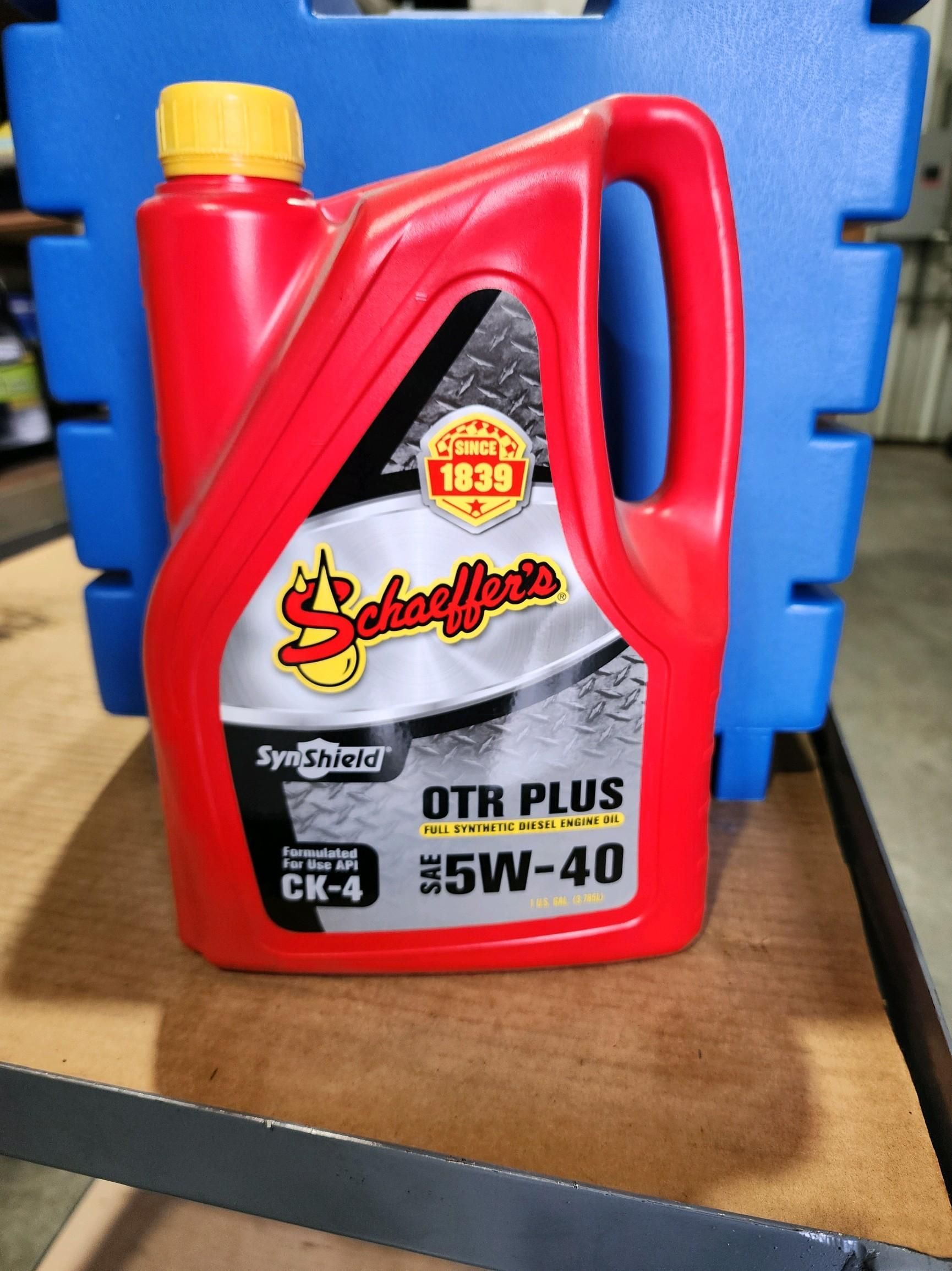 A red bottle of schaeffer 's oil sits on a shelf