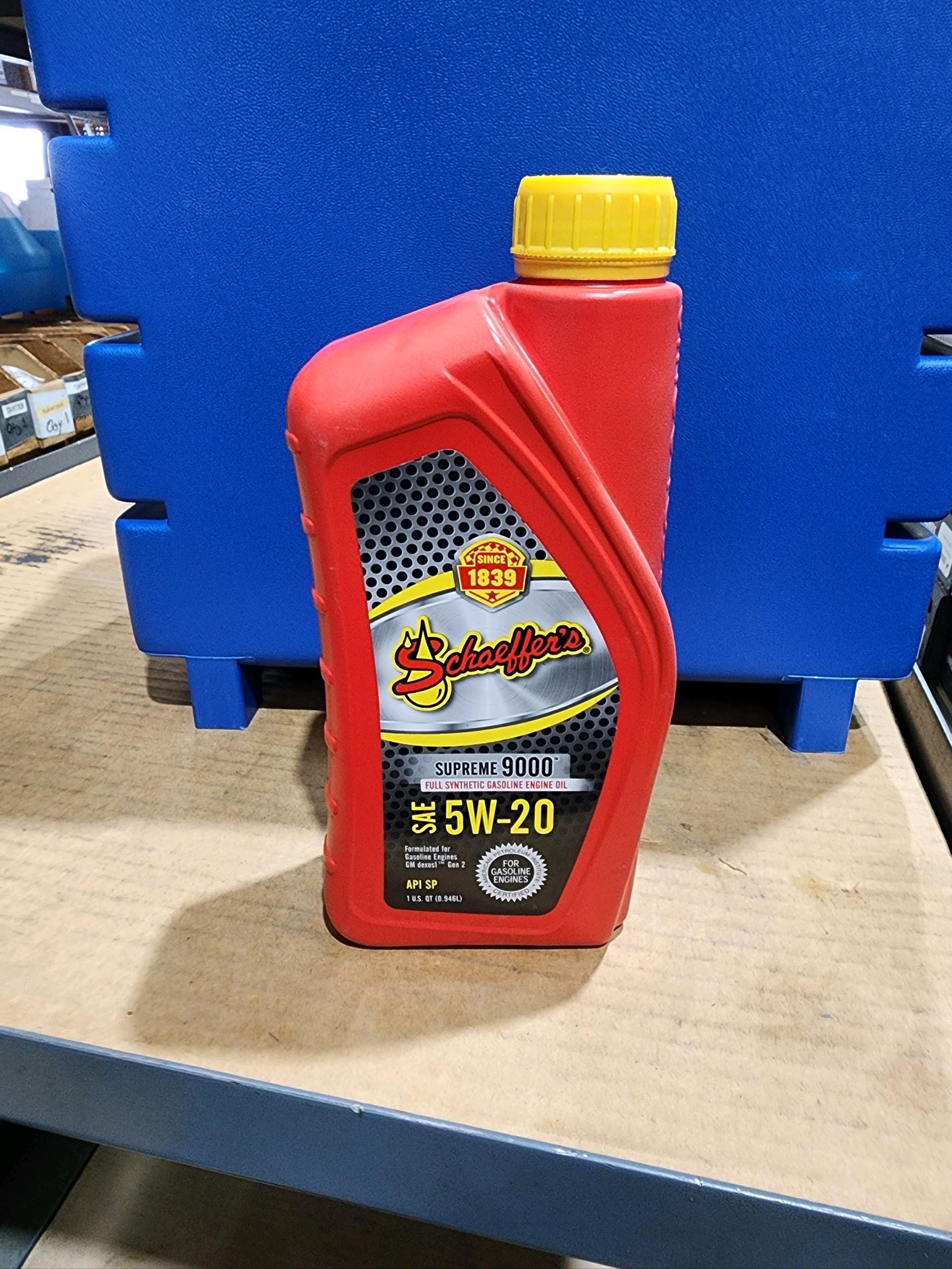 A bottle of oil is sitting on a wooden table.
