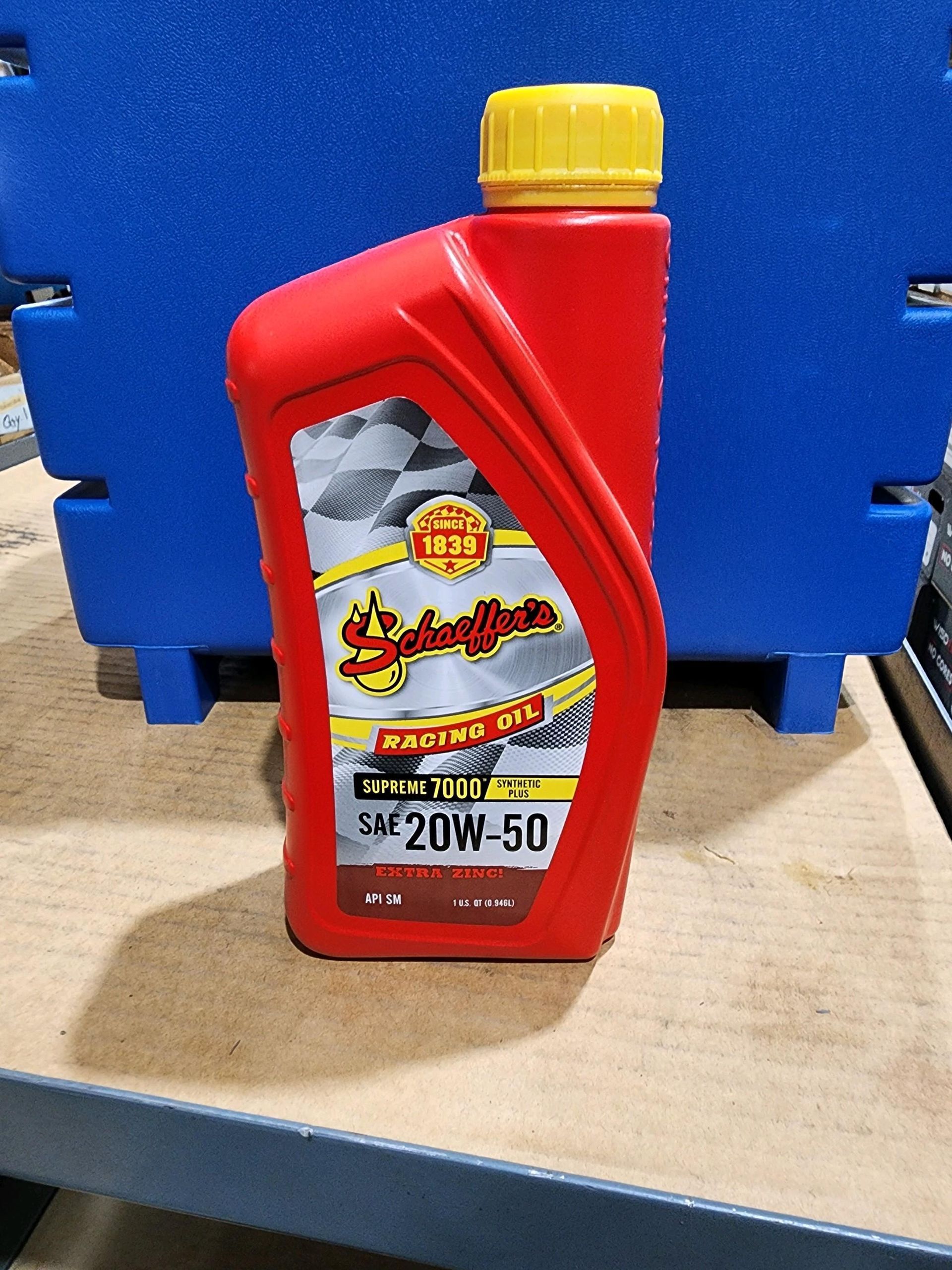 A bottle of engine oil is sitting on a wooden table.