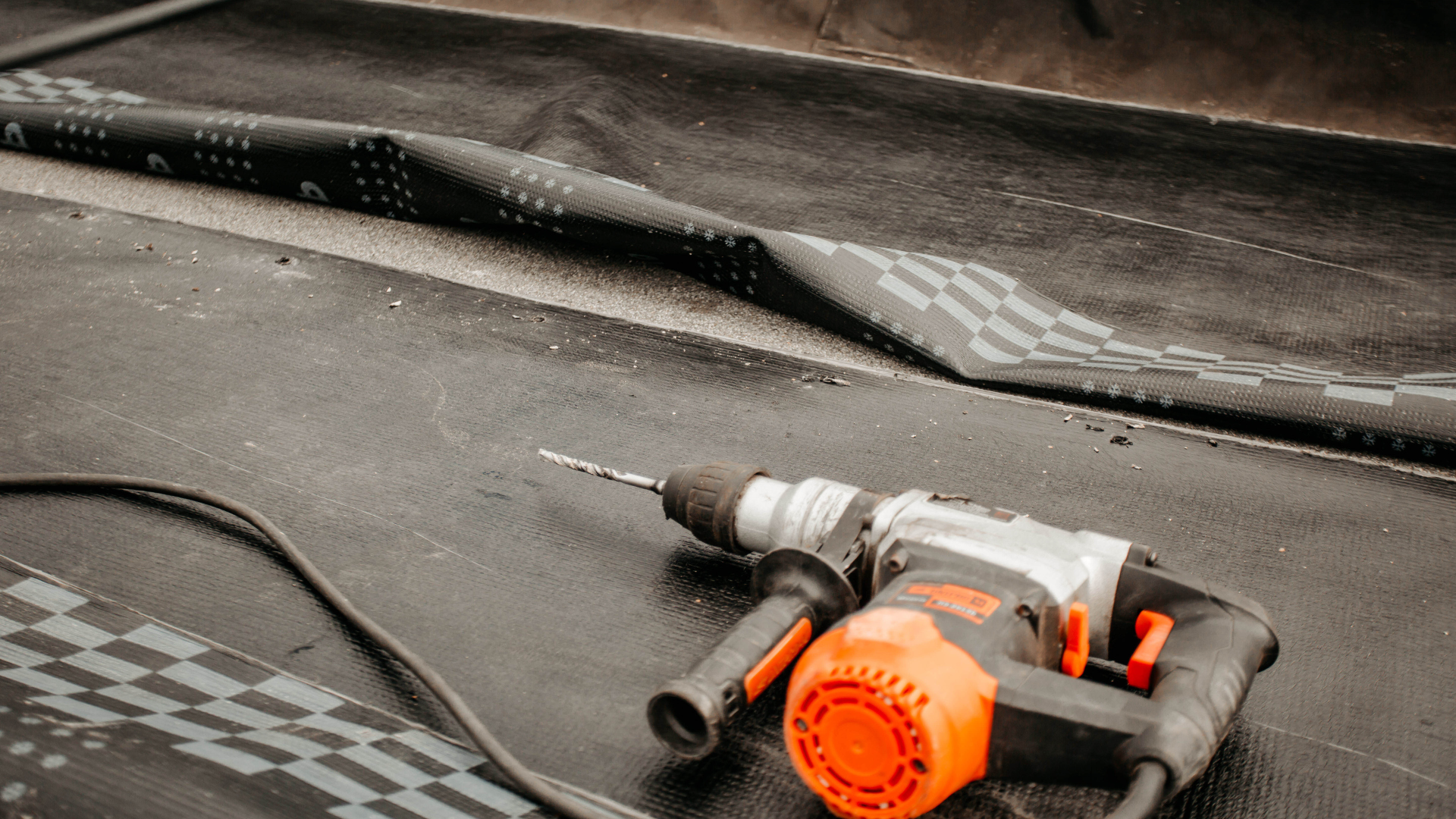 A hammer drill is sitting on top of a black surface.