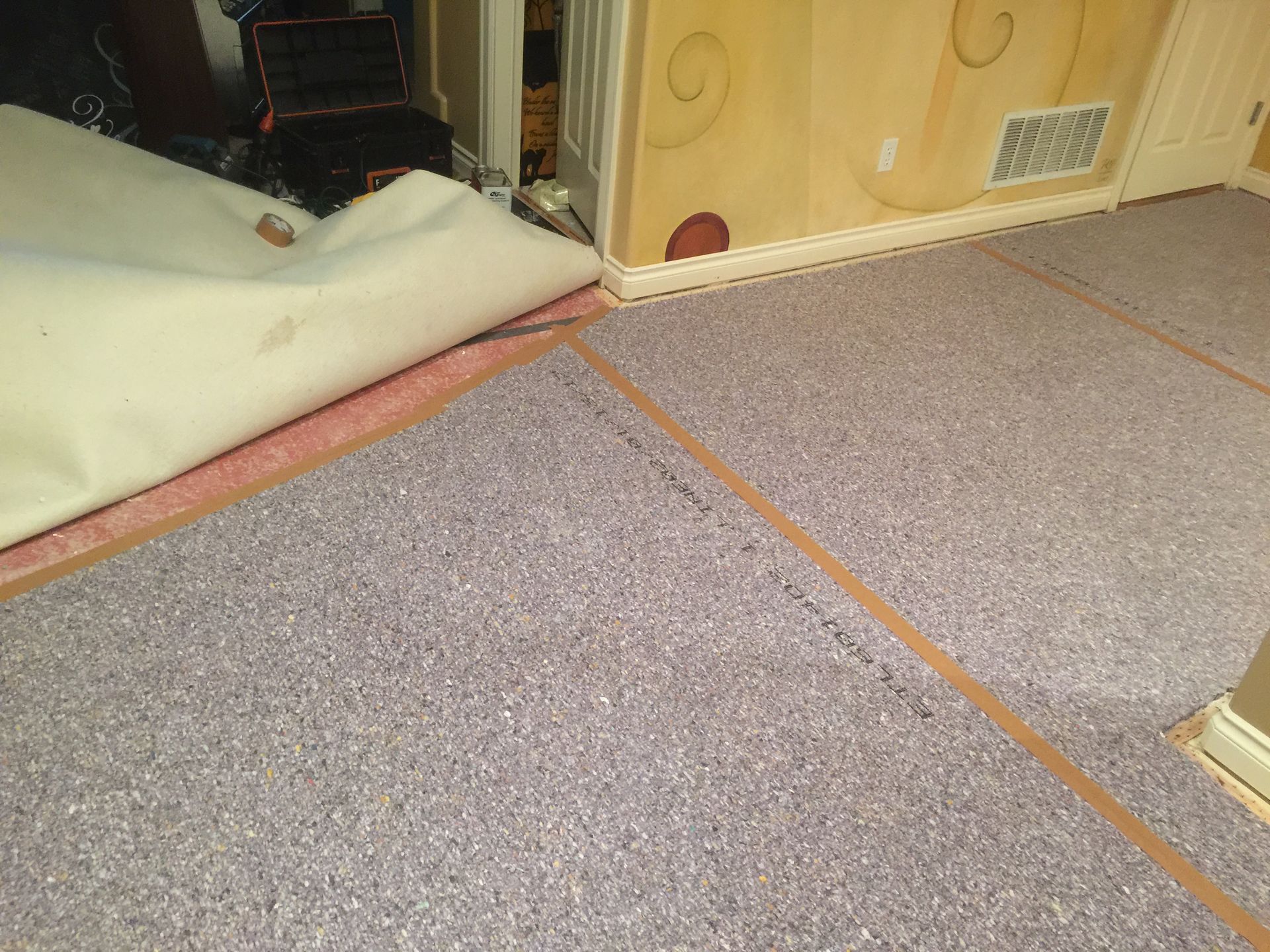 Concrete subfloor with new carpet pad on it after Carpets by Chris Stretching & Repair installed new pad perfectly