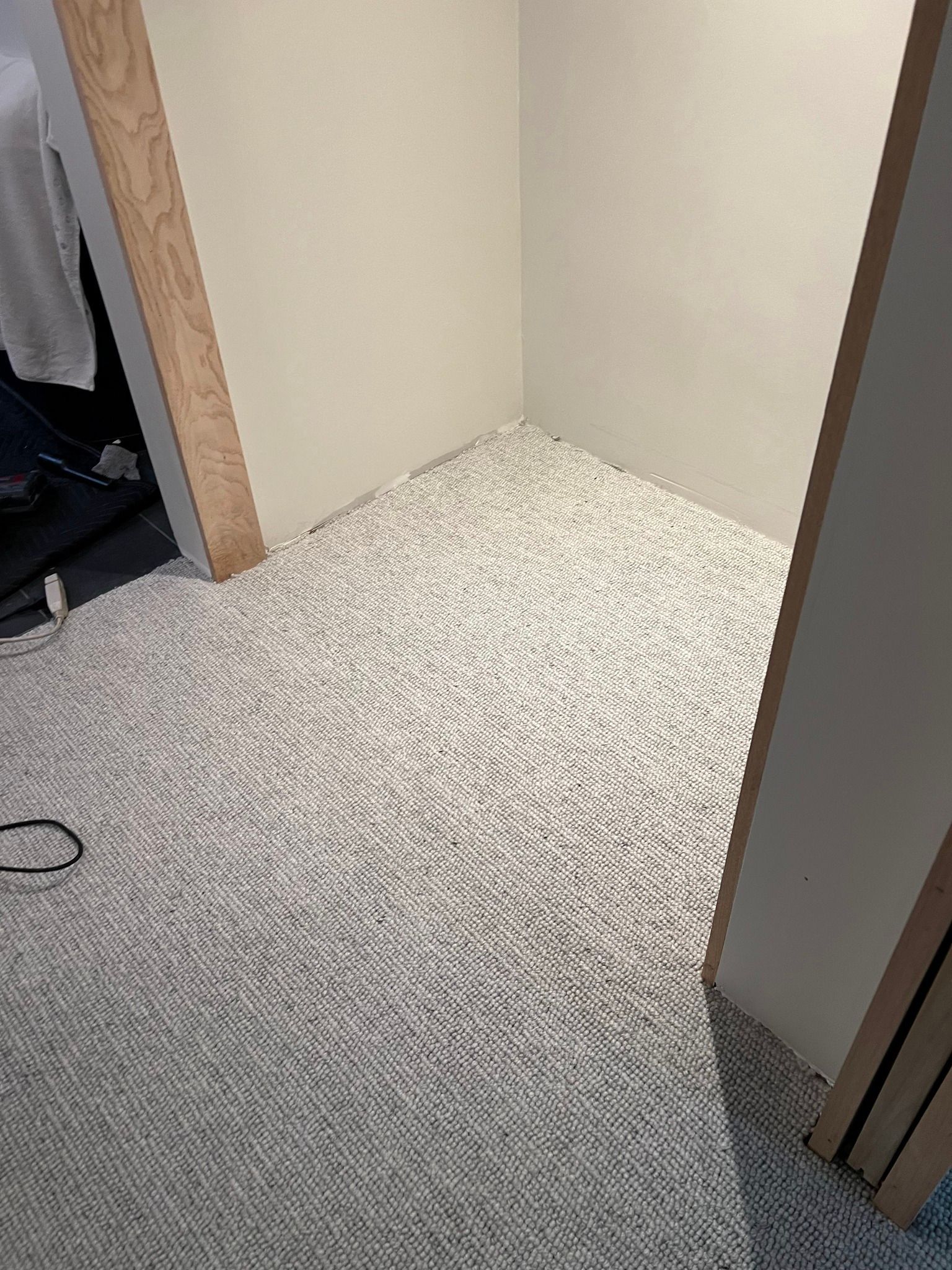 A small room with beige walls and a white patterned carpet.
