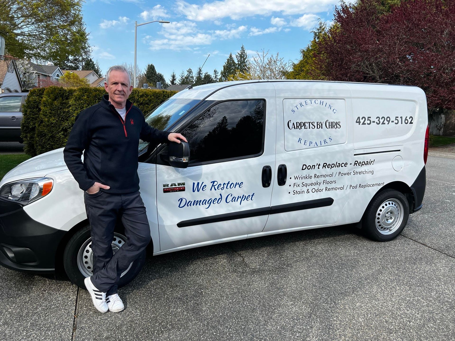 Man stands next to a white van with business logo 