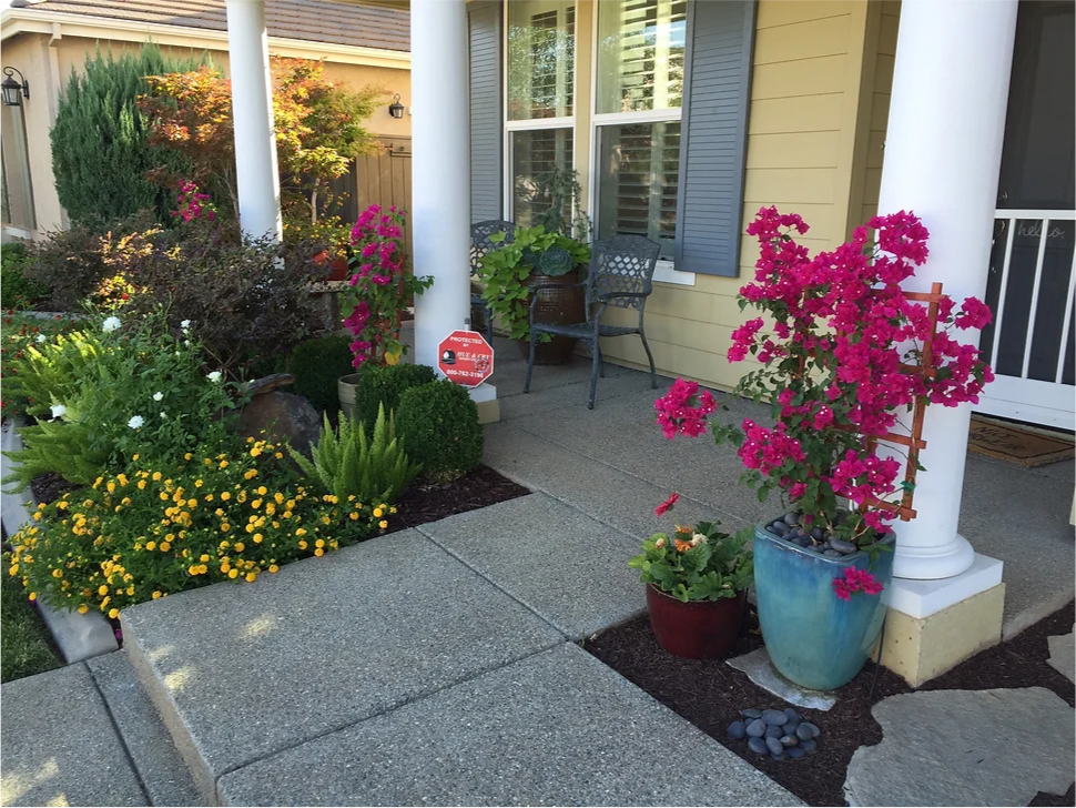 A porch with pink flowers and yellow flowers
