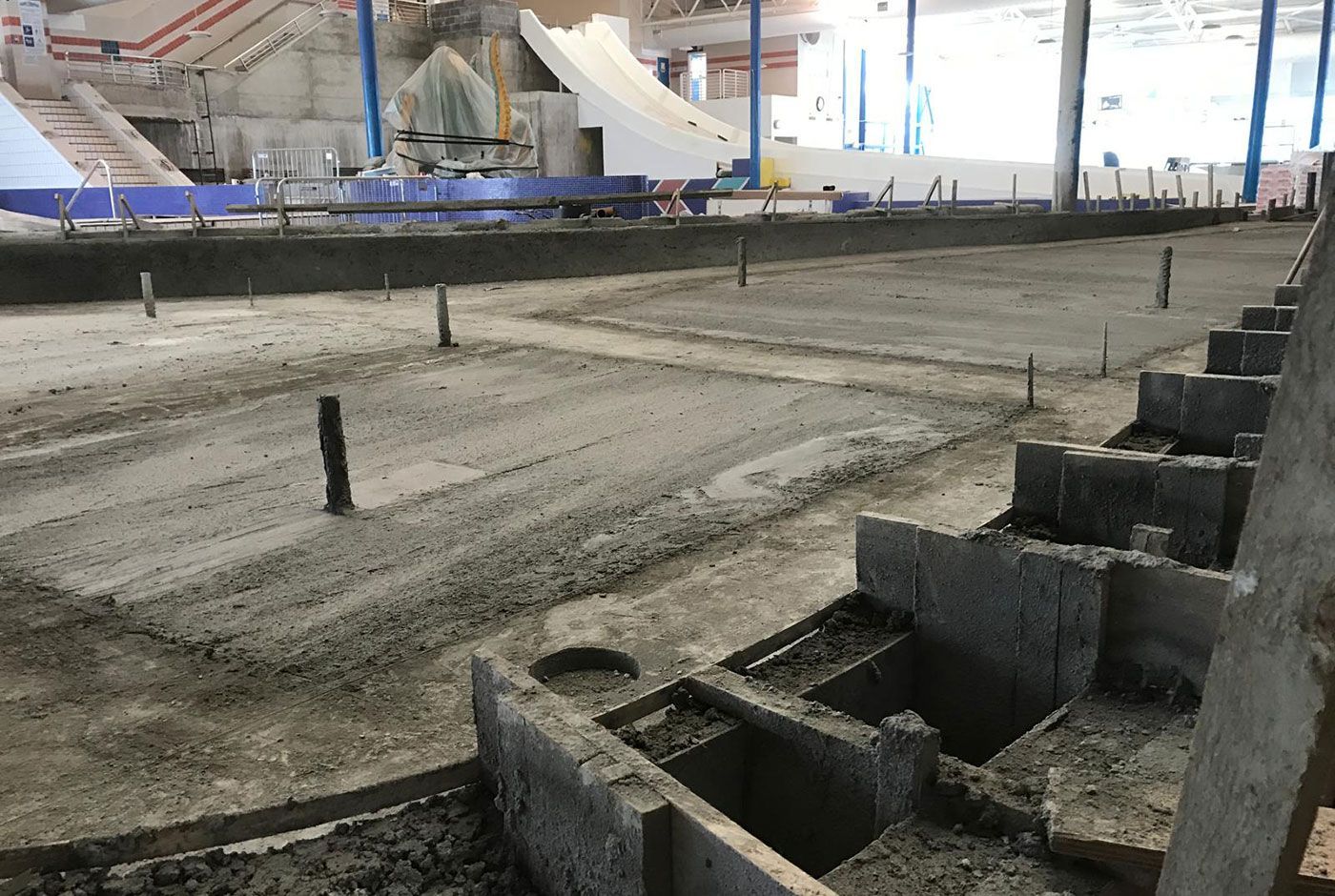 Construction site with concrete foundation forms and rebar in a dirt excavation area