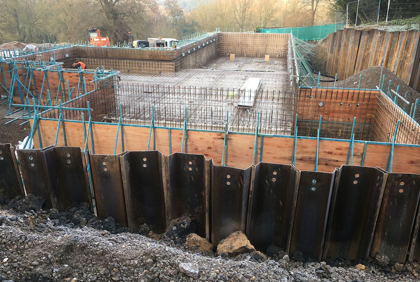 Infinity pool under construction, showing the foundation with steel rebar and wooden formwork surrounding a concrete slab.