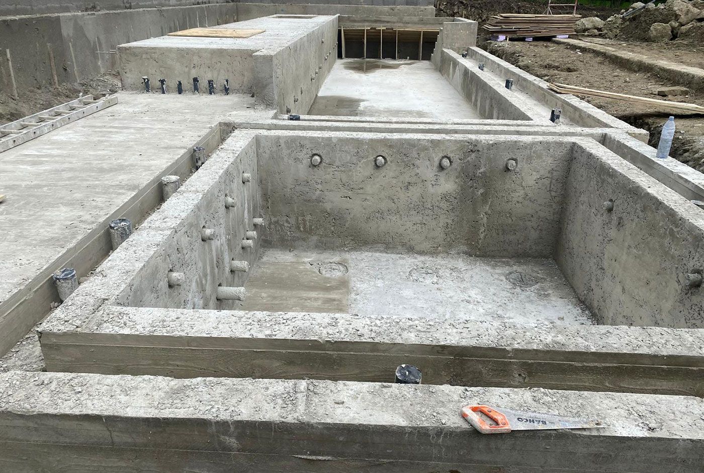 Concrete foundation trenches and footings under construction at the site of a new infinity pool.