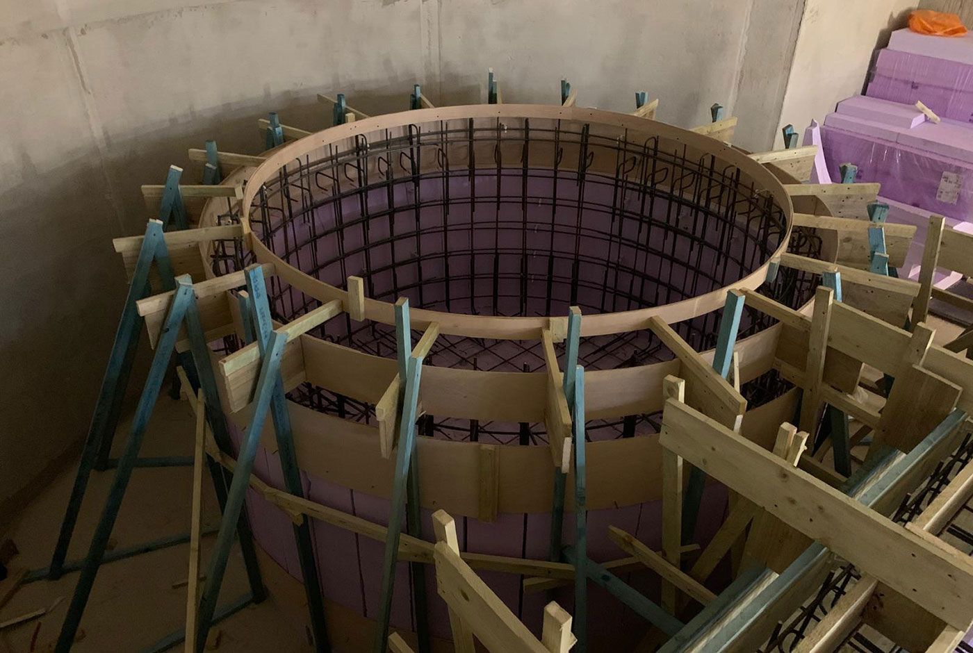 Circular construction formwork for a spa or plunge pool, with wooden braces and rebar grid.