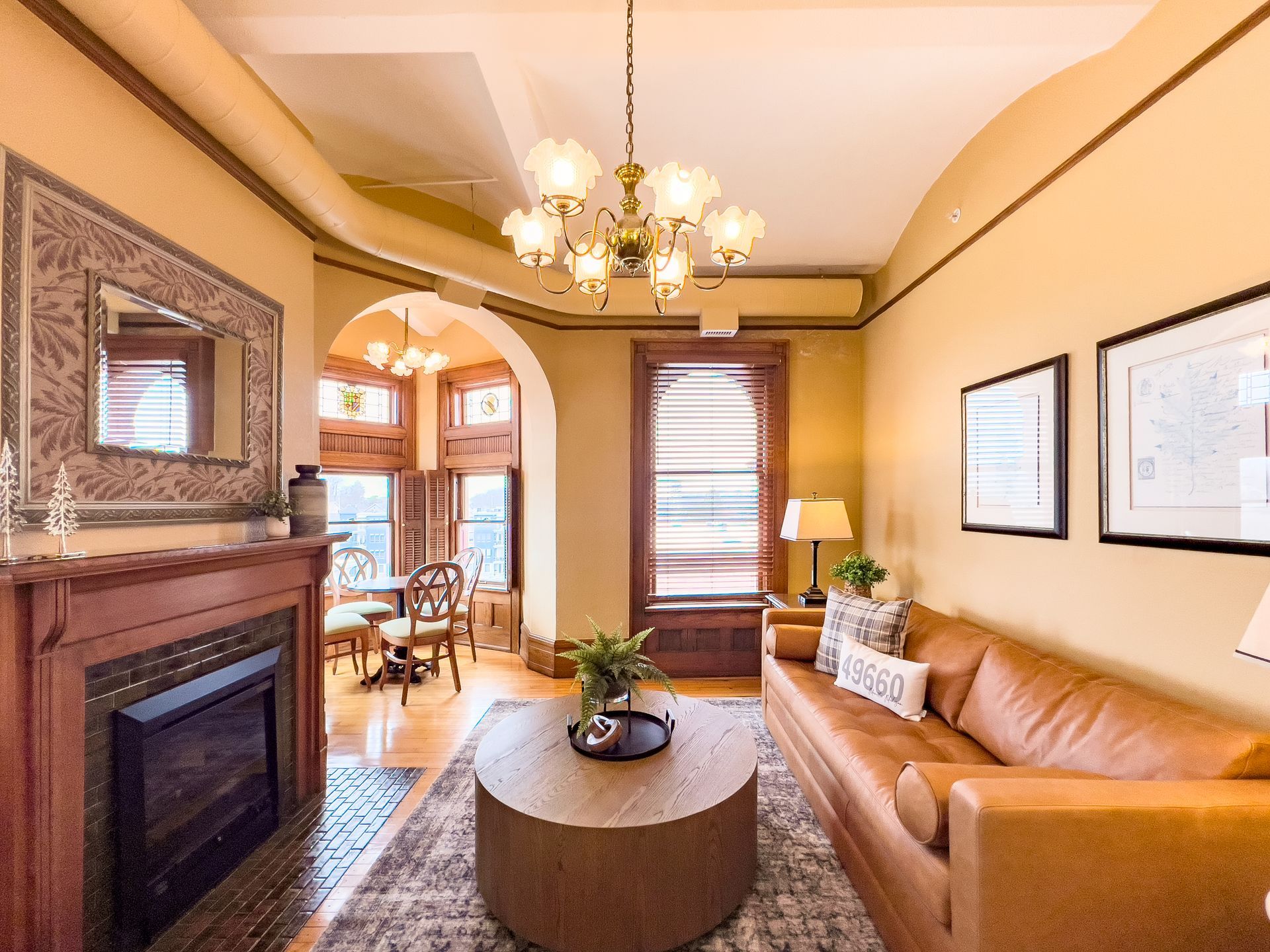 A bedroom with a king size bed , fireplace , chairs and a couch.